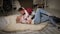 A couple in love in Christmas sweaters lies on the floor on a knitted blanket.