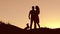 Couple in love dancing silhouette at nature sunset and kissing. Loving man and woman with dog dancing silhouette slow