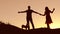 Couple in love dancing silhouette at sunset and kissing. Loving man and woman with dog dancing silhouette slow motion