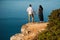 Couple in love at dawn by the sea. Honeymoon trip. Man and woman traveling. Happy couple by the sea view from the back. Man and