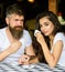 Couple in love drink black espresso coffee in cafe. Man with beard and attractive happy smiling girl hold hands drinking