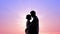 Couple in love embracing heartily against shiny sunrise, tender feelings, kisses