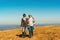 Couple in love enjoying adventure in mountains. Beautiful landscape with blue sky. Young couple hikers holding hands