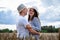A couple in love enjoys relaxing in a wheat field. Romantic couple hugging in a moment of love in a golden wheat field. The