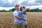 A couple in love enjoys relaxing in a wheat field. Romantic couple hugging in a moment of love in a golden wheat field. The