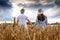 A couple in love enjoys relaxing in a wheat field. A romantic couple walks in a golden wheat field. The concept of people,