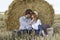 Couple in love in field on hay background. Man kissing a woman tenderly.