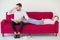 couple in love girlfriend lying down on  red sofa boyfriend massage her feet with unpleasant  Foot odor  at home, indoors . Foul-