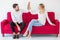 couple in love giving high five on the red sofa  at home, on white background. indoors