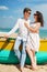 Couple in love of happy man and woman, travel. Beach wooden boat sand