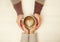 Couple in love holding hands with cup of coffe top view image on white wooden background. Man holds woman`s hand, love cosept.