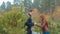 Couple in love holding hands in pine forest laughing and enjoying themselves slow motion