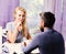 Couple in love holds cups of coffee at table. Woman and flirty face and man have an affair.