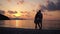 Couple in love hugging each other standing on a beach at sunset over the sea.