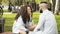 Couple in love kissing, sitting on a bench in a park looking each other