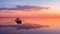 A couple in love look at beautiful sunset in a rowing boat on the lake. Pink sky and vanilla clouds. Romantic scene -