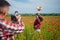 couple in love making photo. man with camera and woman in poppy field. summer flower meadow