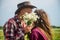 couple in love of man and woman kissing behind daisy bouquet in camomile flower field, romance.