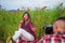 couple in love of man and woman making photo on camera in summer poppy flower field, photographer