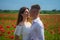 couple in love. man and woman in poppy field. summer flower meadow.