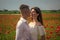 couple in love. man and woman in poppy field. summer flower meadow.