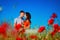 A couple in love a man and a woman in a poppy field on a Sunny day embrace