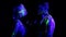 Couple in love painted fluorescent powder dance in ultraviolet light