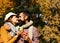 Couple in love at park holds cups of tea or coffee. Relationship and hot beverage concept. Girl and bearded guy