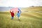 A couple in love running over the meadow with unfurled American flag. Election, campaign, freedom concept