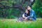 Couple in love sitting and relax on grass embracing each other in park romantic