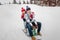 Couple in love sledding in the winter park. Dressed in knit hats, mittens and scarf