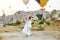 Couple in love stands on background of balloons in Cappadocia. Man and a woman on hill look at a large number of flying balloons