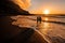 A couple in love stands in the ocean in the evening looking at the beautiful sunset on the island of Tenerife.Spain