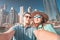 Couple in love takes a selfie in a seaport with a view of huge skyscrapers. Romantic honeymoon trips to Dubai Marina