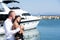 Couple in love travelling, honeymoon time. Young couple hugs and relaxing at dock near boat, on sunny summer day. Woman