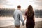 Couple in love walking along the lakeside on the background of trees