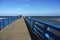 A couple in love walking along the promenade, pier protruding into the sea