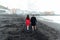 Couple in love walking on the beach near the powerful ocean with the sunset in Puerto de la cruz