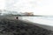 Couple in love walking on the beach near the powerful ocean with the sunset in Puerto de la cruz