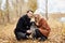 Couple in love on a warm autumn day walks in the Park with a cheerful dog Spaniel. Love and tenderness between a man and a woman