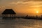 Couple in love at a wooden pier palapa enjoying Sunset at Holbox island near Cancun, Traveling Riviera Maya. Mexico adventure.