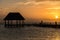 Couple in love at a wooden pier palapa enjoying Sunset at Holbox island near Cancun, Traveling Riviera Maya. Mexico adventure.