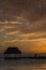 Couple in love at a wooden pier palapa enjoying Sunset at Holbox island near Cancun, Traveling Riviera Maya. Mexico adventure.