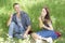 Couple lovers blow bubbles. friends laugh. summer picnic boy and girl are sitting on grass