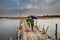 couple of lovers crossing old traditional bamboo wooden bridge across Mekong river