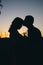 A couple of lovers at sunset. Only shadows and silhouettes are visible. Romantic look and place for text. Golden rays and black
