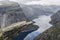 Couple lying down on trolltunga troll`s tongue rock , Norway