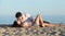 Couple lying and flirting on the sand of the beach