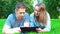 Couple lying in the park and using tablet pc.