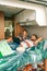 Couple lying watching a movie with messy clothes and shoes under the bed of their campervan